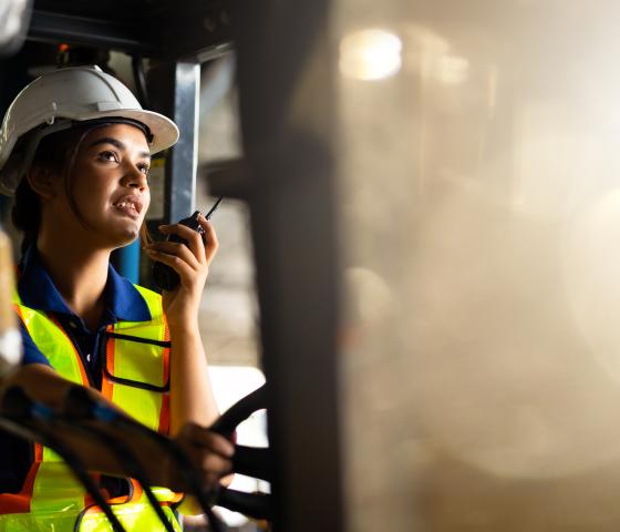 person in hi vis wearing a helmet and using a radio