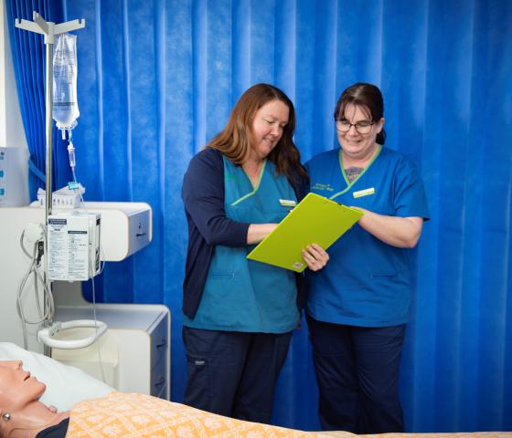 Two nursing students reviewing a patients chart